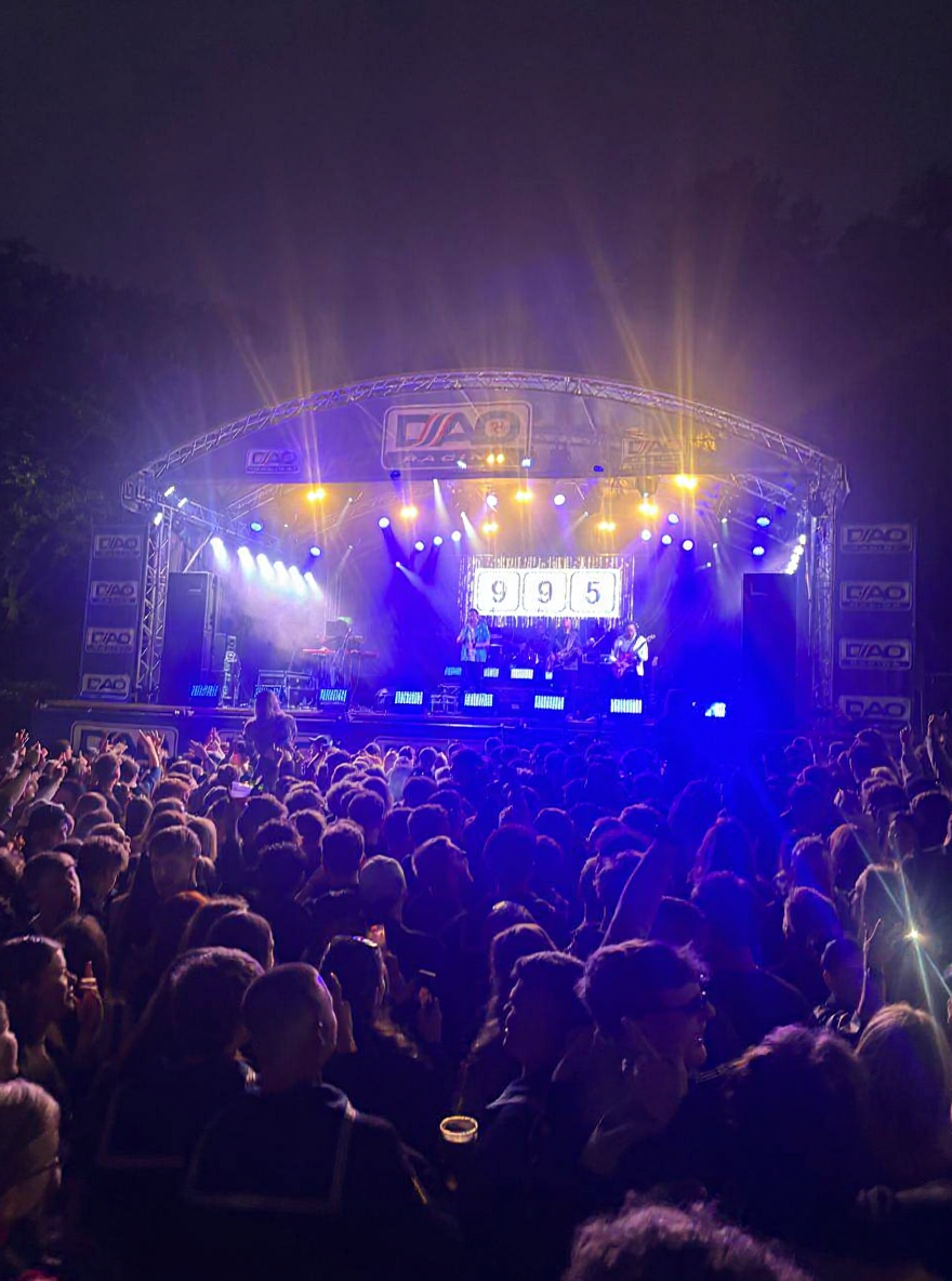 A crowd at an open-air live music night under stage lights on the Isle of Man